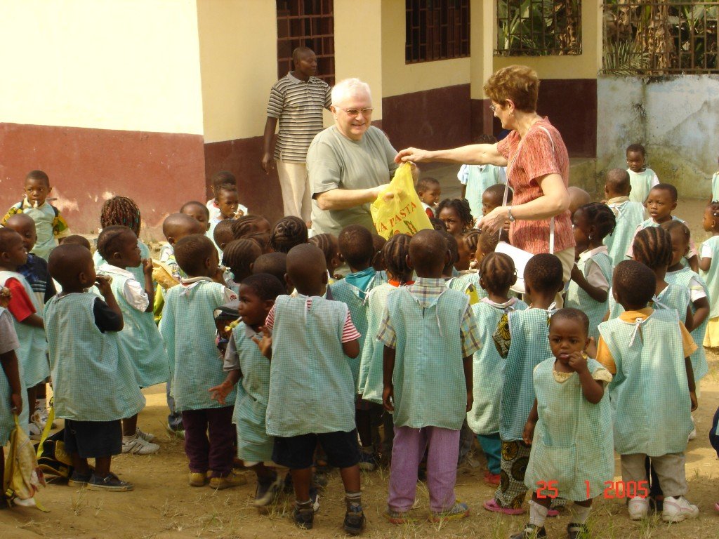 Edouard et Irène distribuant des bonbons aux enfants de l'école maternelle de Souza.